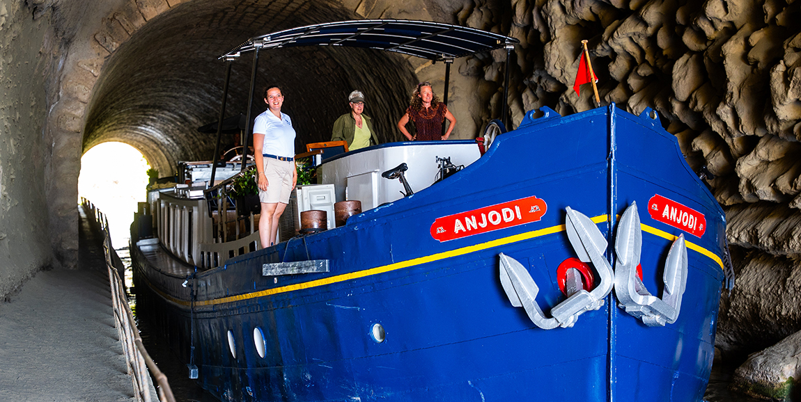 Guests travel through the oldest tunnel on the Canal du Midi on board hotel barge Anjodi